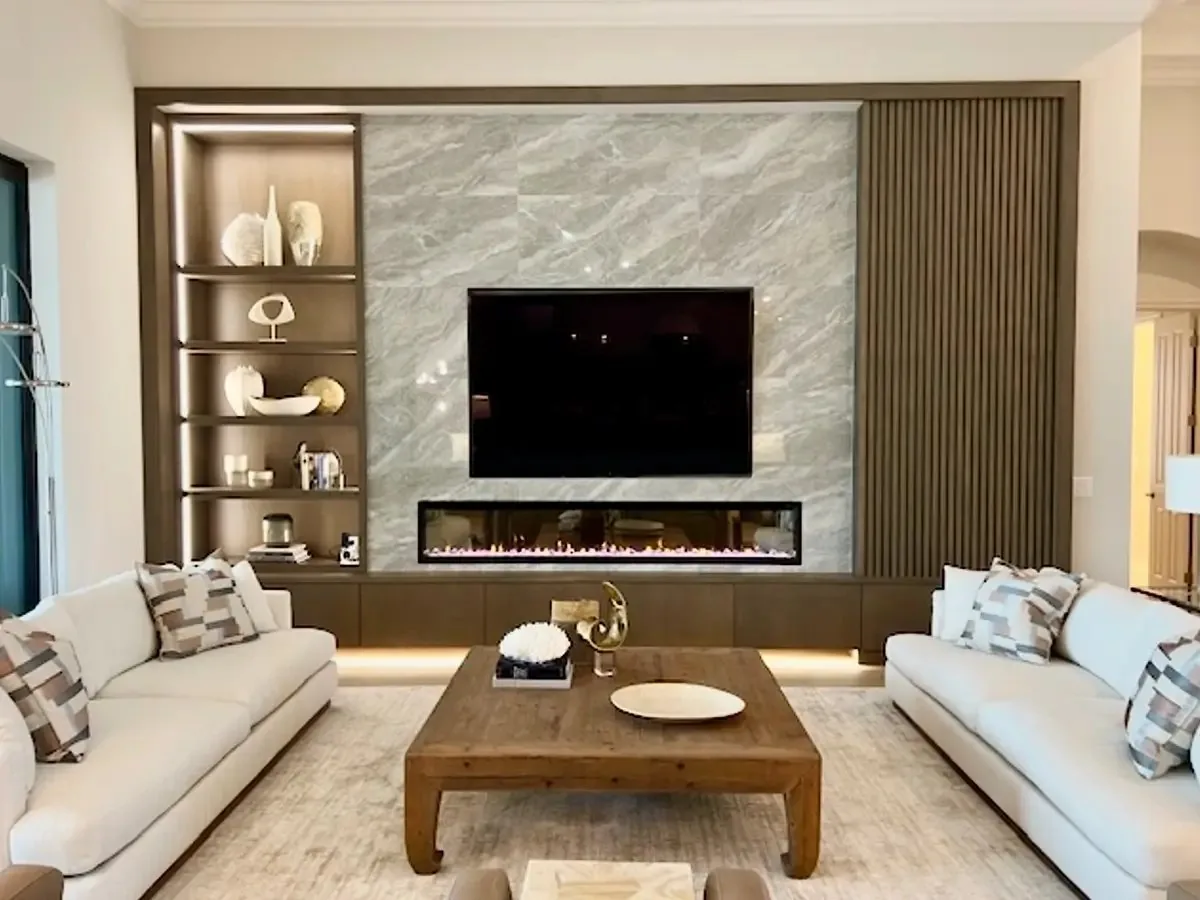 Custom walnut entertainment center with integrated lighting, fireplace and stone backing, built by Pohl Custom Cabinets